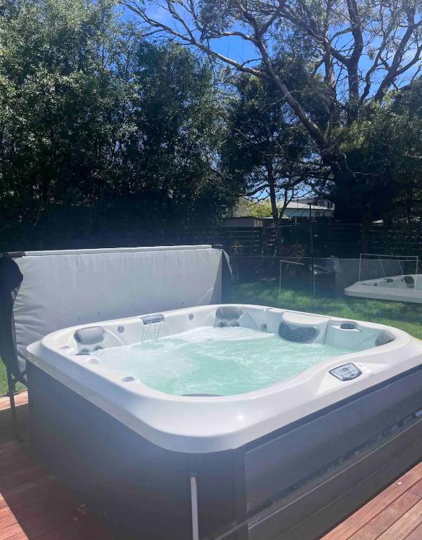 a jacuzzi tub sitting on top of a deck at Homey Beach Cottage with Spa, walk to beach in Cowes