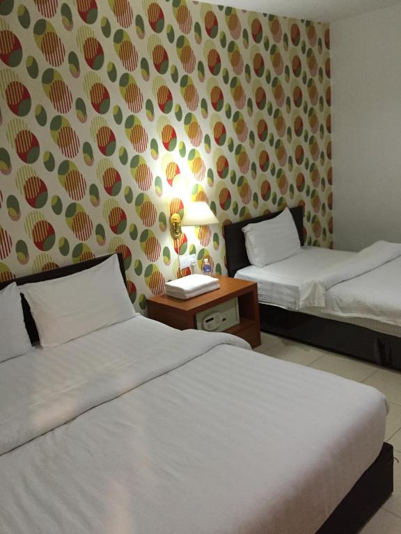 Postel nebo postele na pokoji v ubytování Permai Hotel