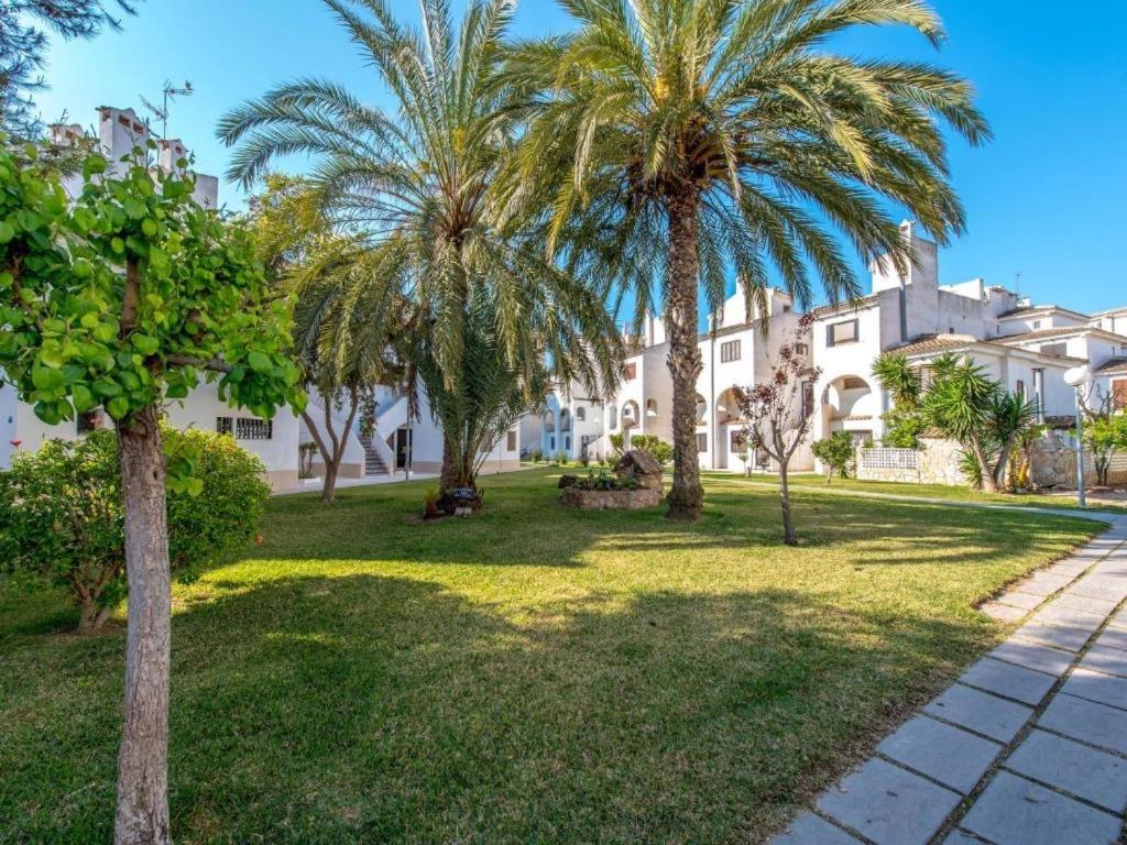 a park with palm trees in front of a building at Villa Corazon in Torrevieja