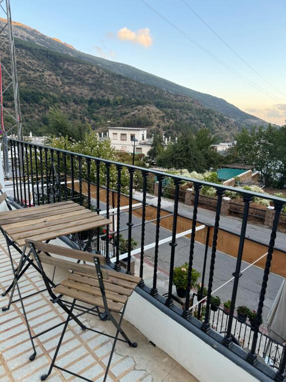 a balcony with a bench and a view of a street at Apartamento rural Julio in Trevélez