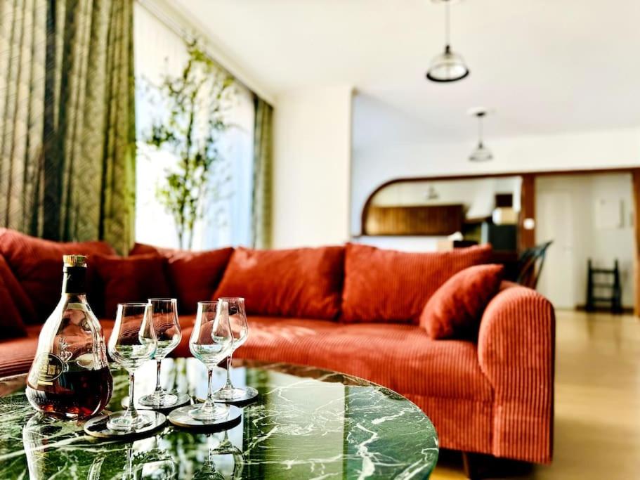 - un salon avec un canapé et une table en verre avec des verres à vin dans l'établissement Casa Luciano, à Dunkerque