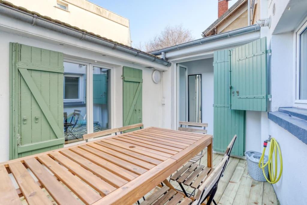 un banc en bois assis sur une terrasse à côté d'un bâtiment dans l'établissement Badalux - Paris, CDG, Expo Parc, StadeDeFrance, à Aulnay-sous-Bois