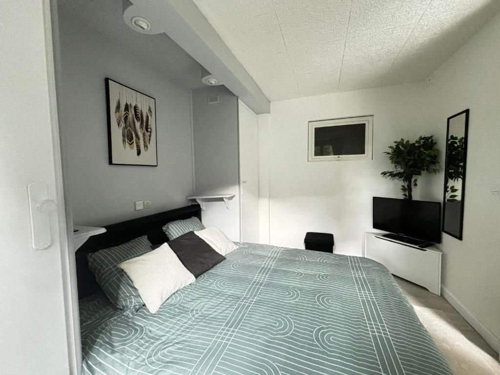 En eller flere senge i et værelse på Joli T2 avec jardin - calme & chaleureux