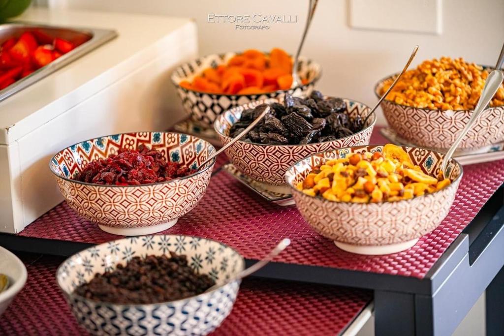 a bunch of bowls of food on a table at Suimi's Hotel in Villasimius