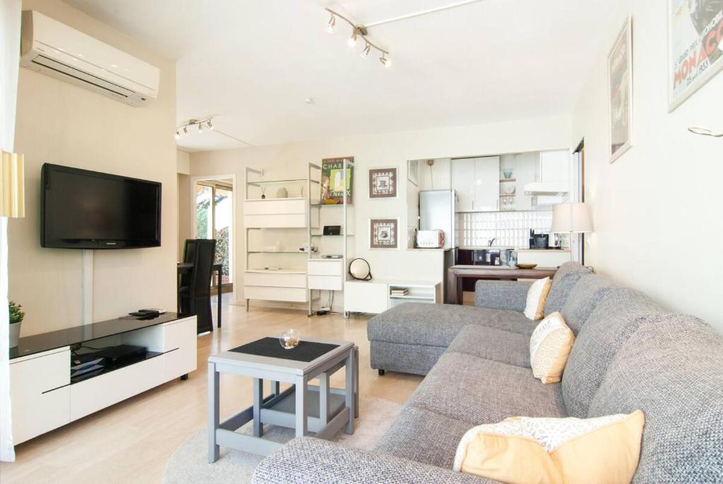 un salon avec un canapé et une télévision dans l'établissement Elegant Apt w/2 Terraces/Mins to Beach & Shops, à Antibes