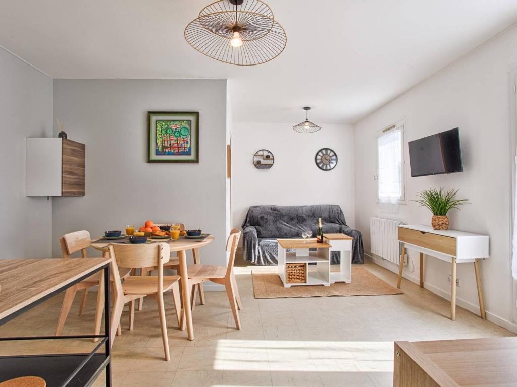 un salon avec une table et un canapé dans l'établissement Joli 2P avec jardin privé à Merville-Franceville, proche plage et commerces - FR-1-788-30, à Merville-Franceville-Plage