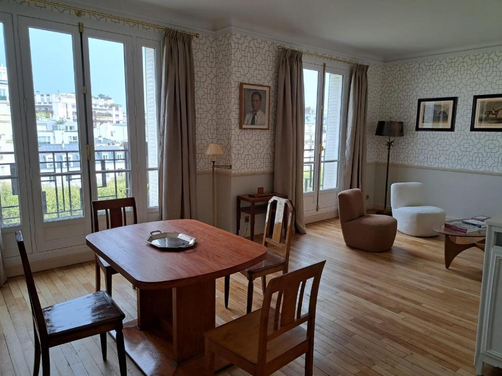 un salon avec une table, des chaises et un canapé dans l'établissement Bright & elegant appartment with view over Invalides, near St Germain des Prés, à Paris