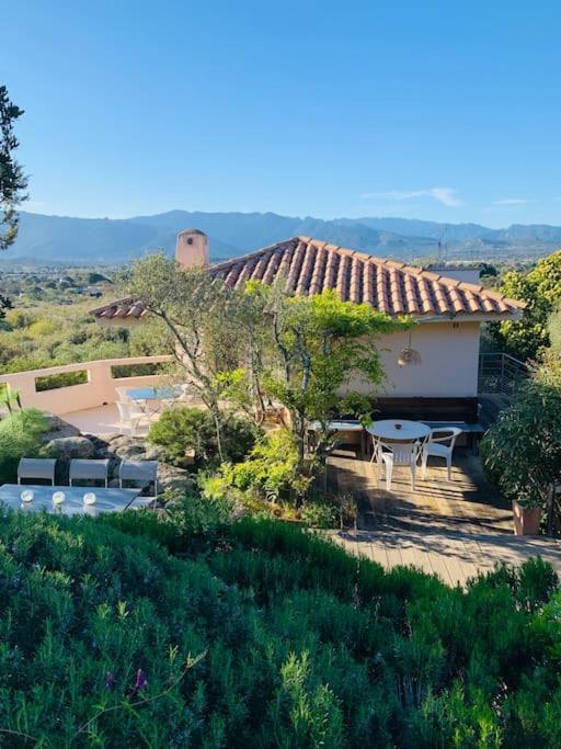 une maison avec une terrasse, une table et des chaises dans l'établissement Sea view villa - Cala Rossa private park, à Lecci