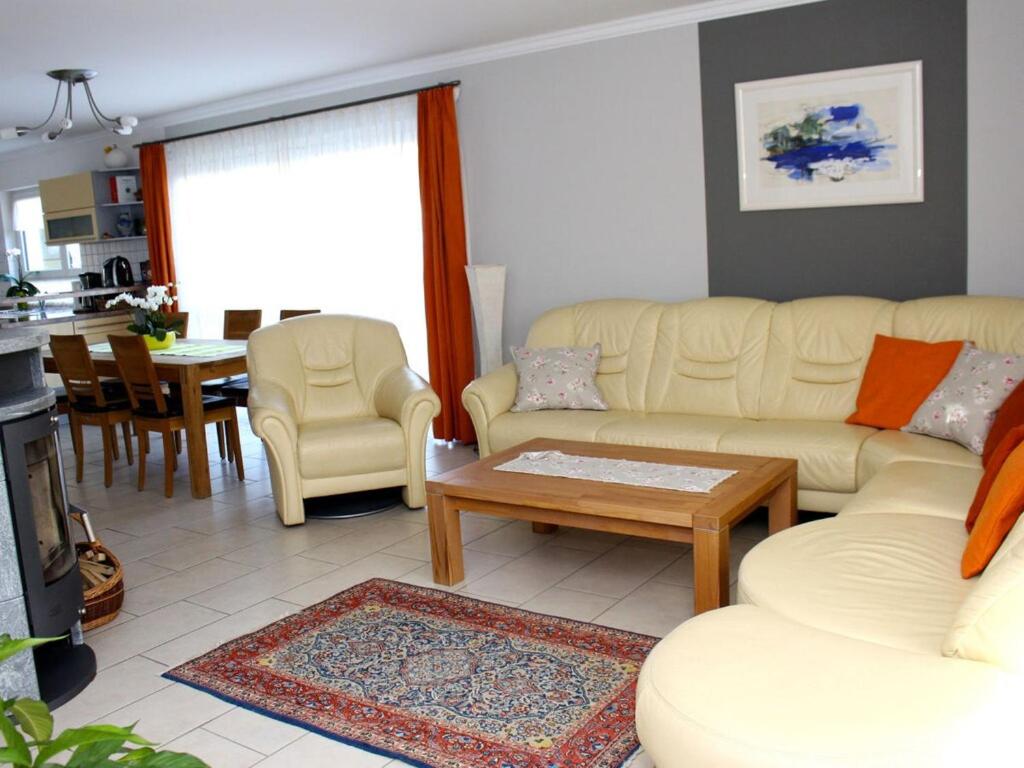 a living room with a couch and a table at Holiday apartment in the rose garden in Birach