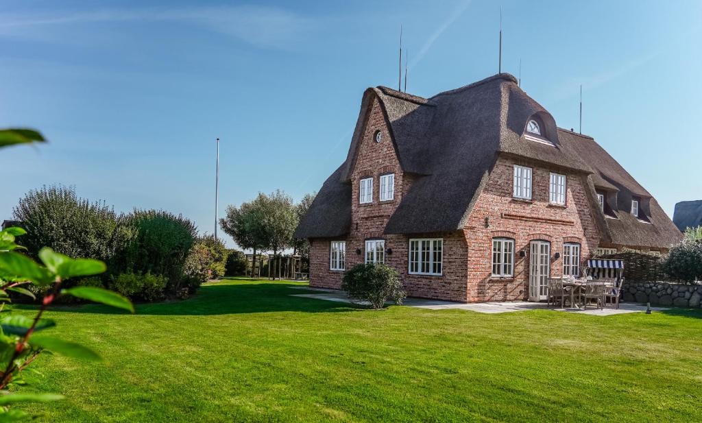 una grande casa in mattoni con tetto nero di LITZKOW 16204 ad Archsum