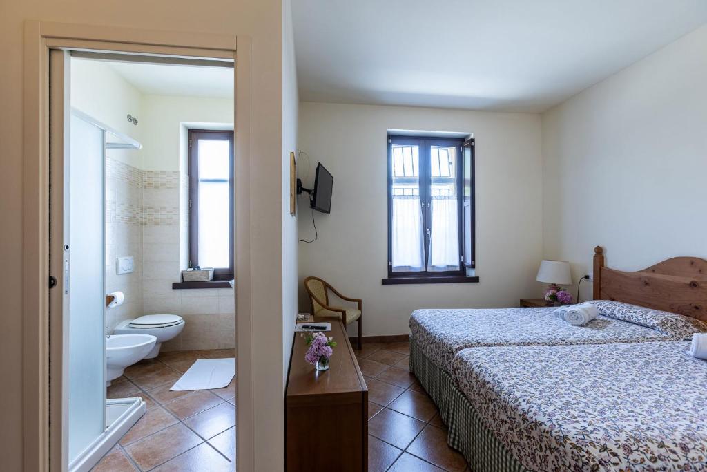 a bedroom with a bed and a bathroom with a toilet at Cascina Gaggioli in Milan