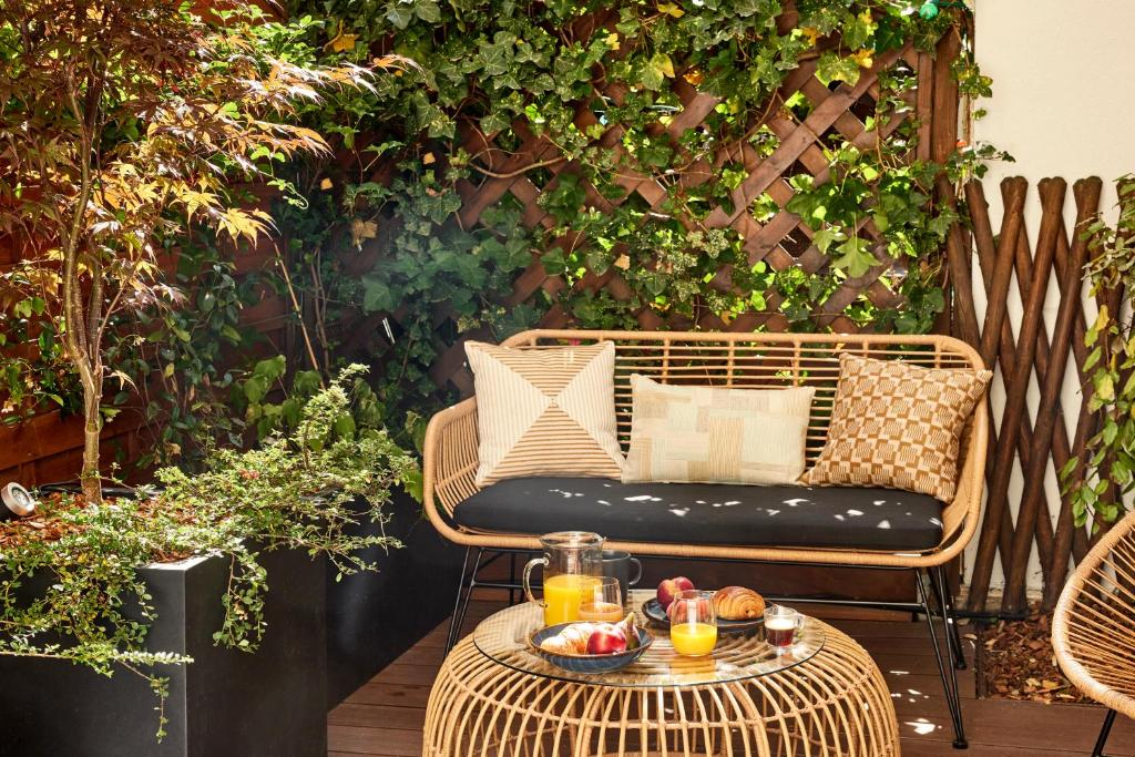 une chaise en osier et une table avec des boissons sur une terrasse dans l'établissement Stylish 2BR & 2BA with private terrace, à Paris