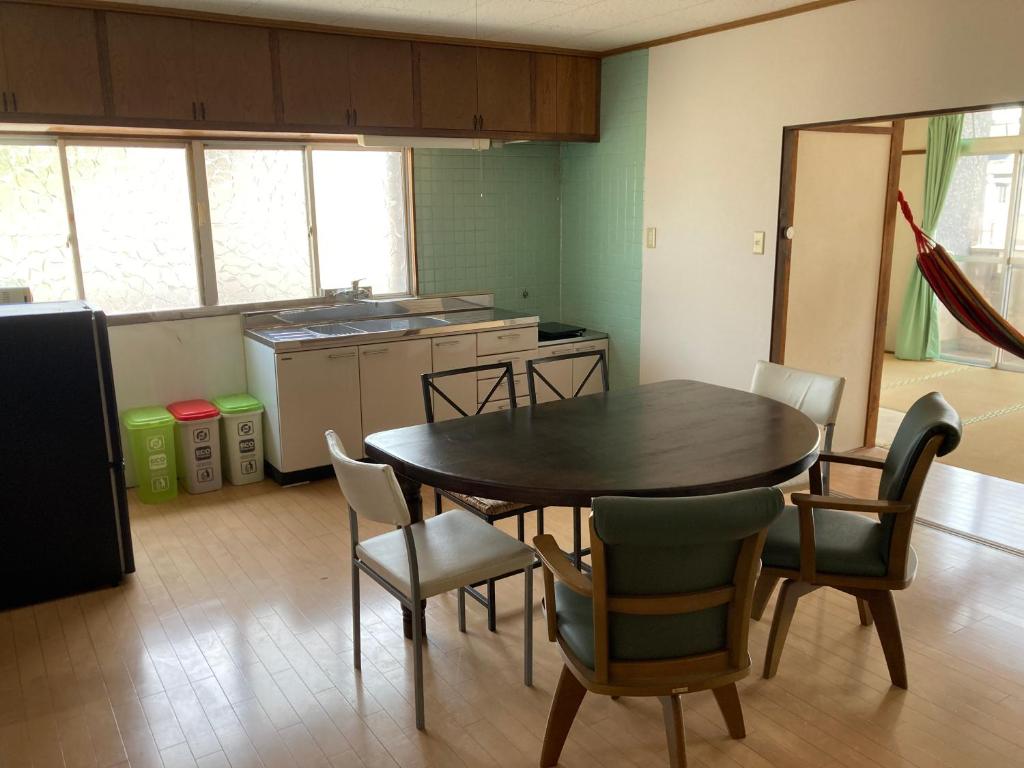 a kitchen with a table and chairs in a room at Oita City Vacation Condominium in Oita