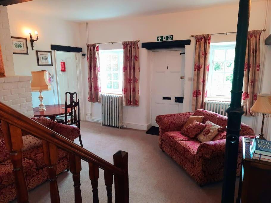ein Wohnzimmer mit Couch und Tisch in der Unterkunft 4 Bedroom Cottage in Wickwar, The Old Stables Guest House in Wickwar