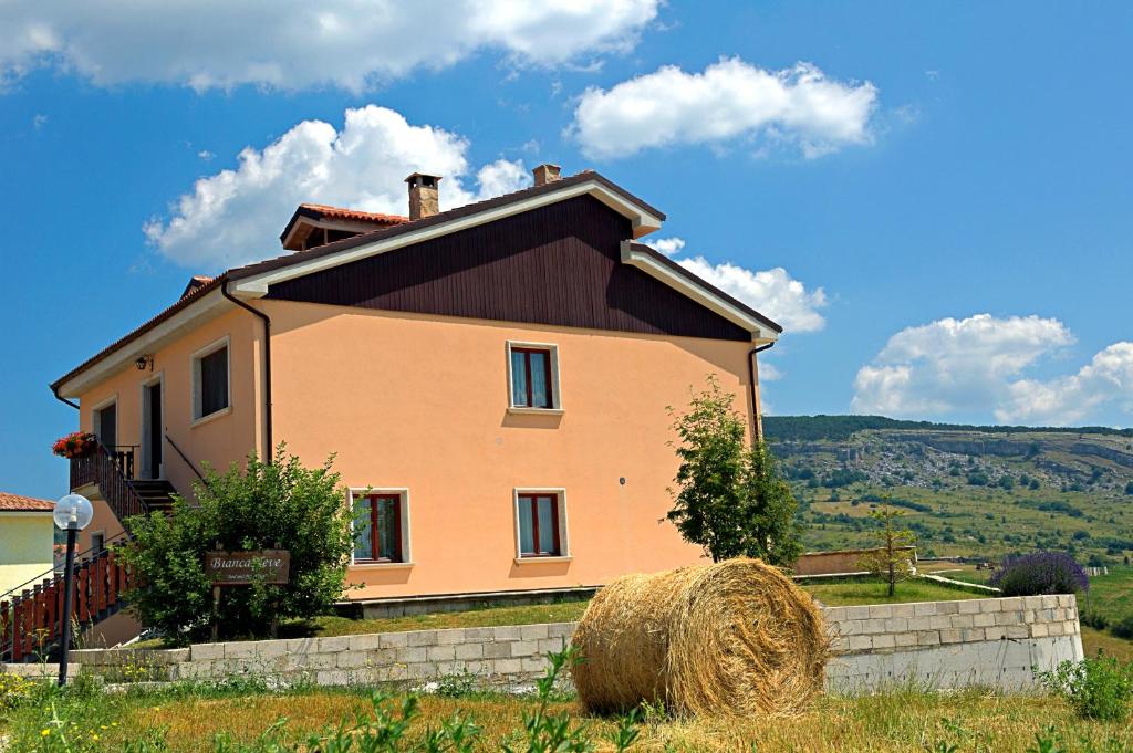 una casa grande con fardos de heno delante de ella en BiancaNeve B&B, en Capracotta