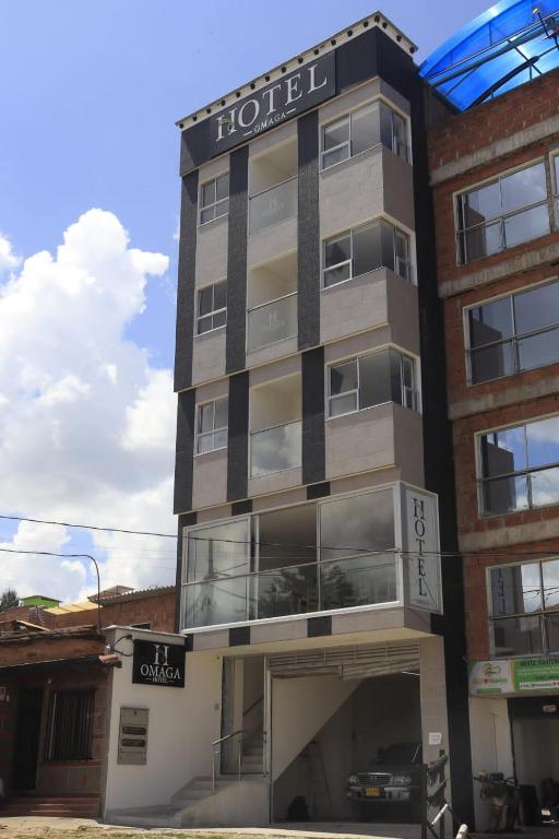 a hotel building with a clock on the side of it at Hotel Omaga El peñol- Guatape in El Peñol