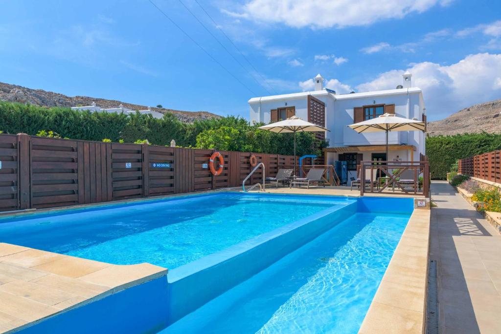 a villa with a swimming pool and a house at Lindos Sapphire in Lindos