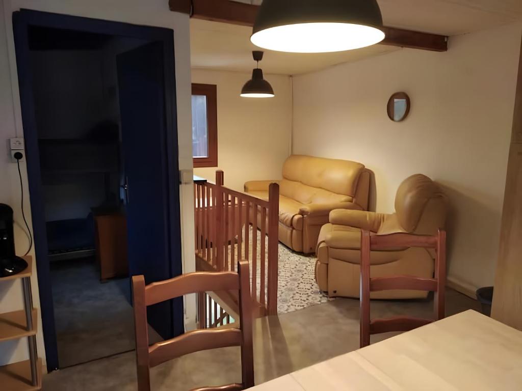 un salon avec un canapé, des chaises et une table dans l'établissement Maison Dans les Pyrénées audoises, à Roquefeuil
