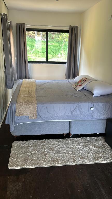 un letto grande in una camera da letto con finestra di Refugio do Capivari a Represa Capivari