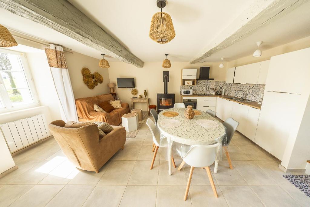 une cuisine et un salon avec une table et des chaises dans l'établissement La fermette d'Emilienne, à Le Val-Saint-Père