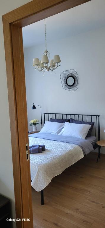 Un dormitorio con una cama y una lámpara de araña. en Sun Shine apartment, en Liepāja