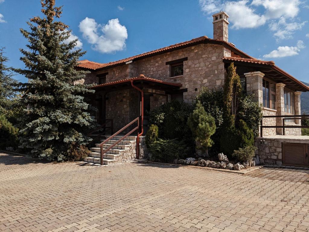 a brick house with a tree in front of it at Chalet Panorama -Three Level Escape in Parnassos in Arachova