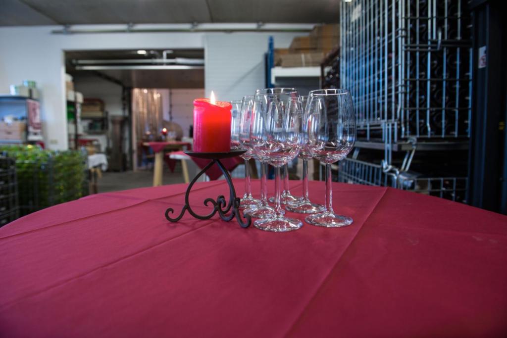 a group of wine glasses and a candle on a table at Remushof Jagschitz in Oslip