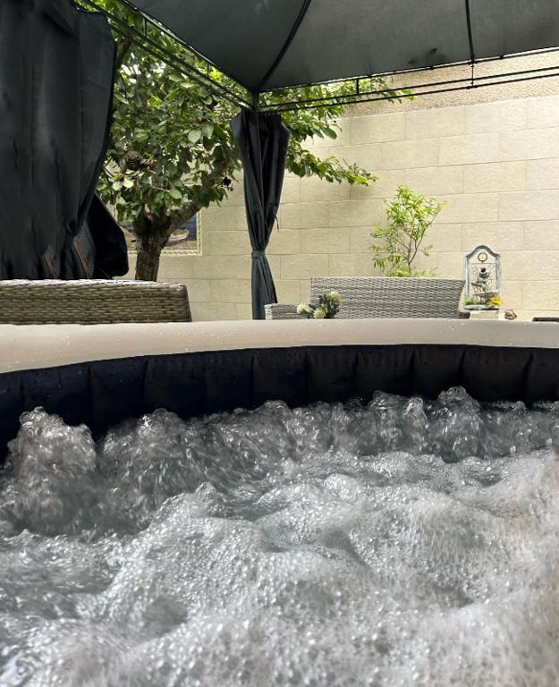 - un bain à remous avec de l'eau en face d'un bâtiment dans l'établissement Studio jacuzzi à l'abri des vents, à Carcassonne