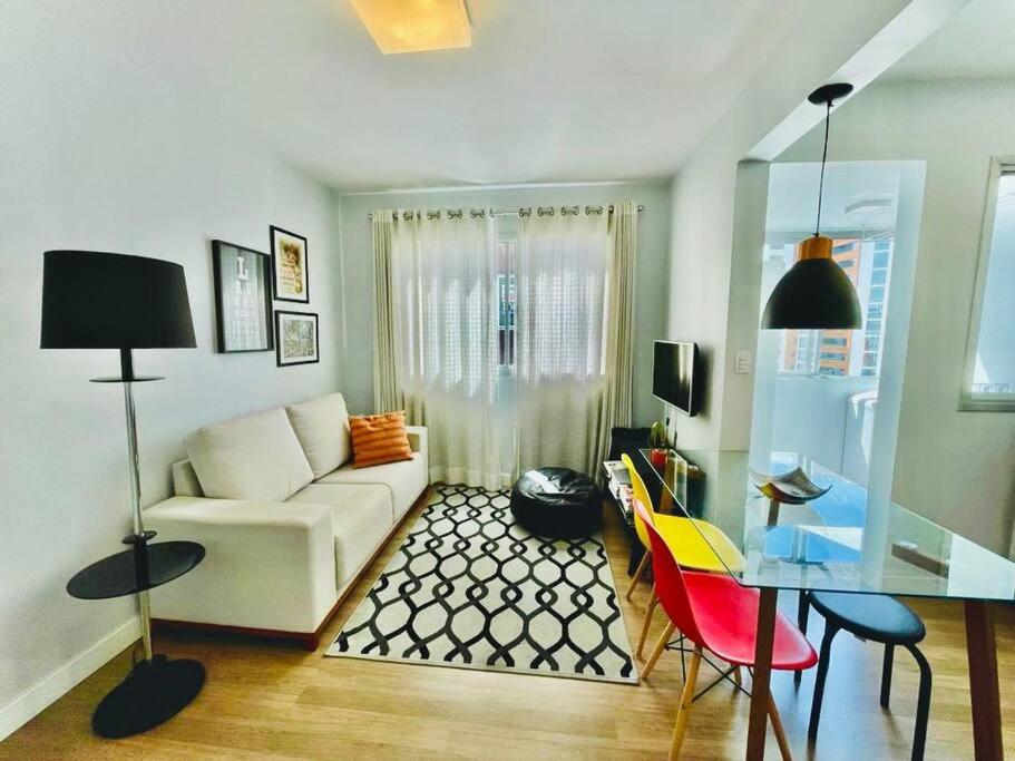 a living room with a white couch and a table at Apto Aconchegante em Floripa in Florianópolis