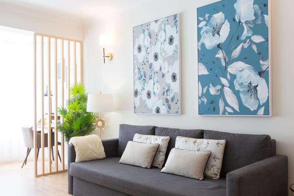 un salon avec un canapé bleu avec des oreillers dans l'établissement Beachome4u6 - luxury apartment, à Carcavelos