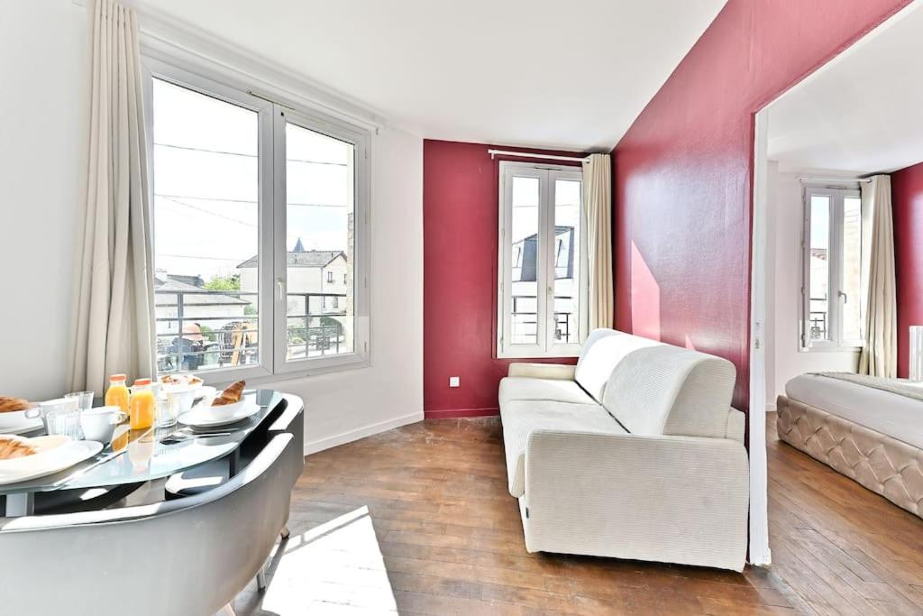 un salon avec un canapé blanc et une table dans l'établissement Appartement Rose Moderne Proche de la capitale III, à Gagny