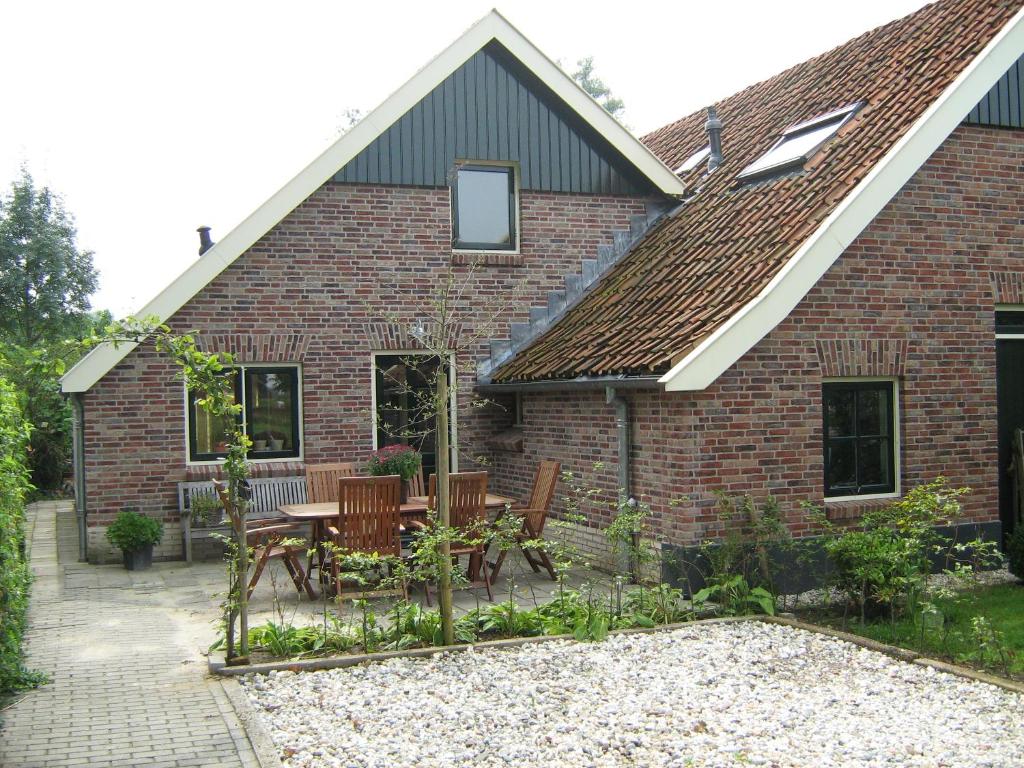 a patio with a table and chairs in front of a brick house at Spekenbrink-Haaksbergen in Haaksbergen