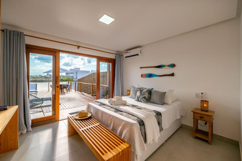 a bedroom with a large bed and a balcony at Bahia Soul - Lake House - Barra Grande - Península de Maraú in Barra Grande