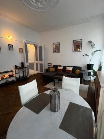 un salon avec une table, des chaises et un canapé dans l'établissement Le St Pierre Face au Château Appart in Nantes, à Nantes