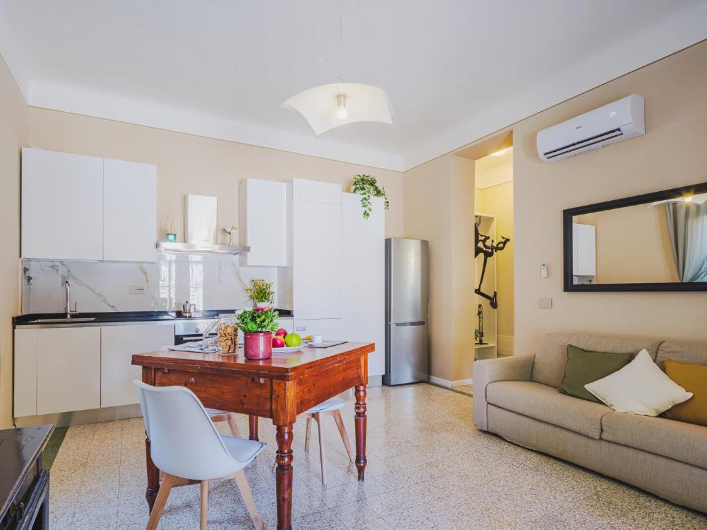 a kitchen and living room with a table and a couch at Marilla Apartment in Capannori
