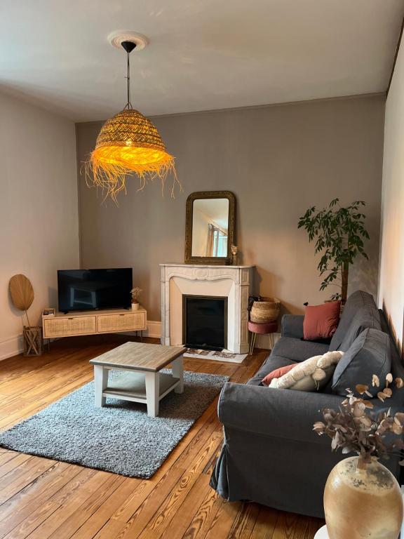 un salon avec un canapé et une cheminée dans l'établissement Appartement 2 chambres - Proche gare, à Nevers