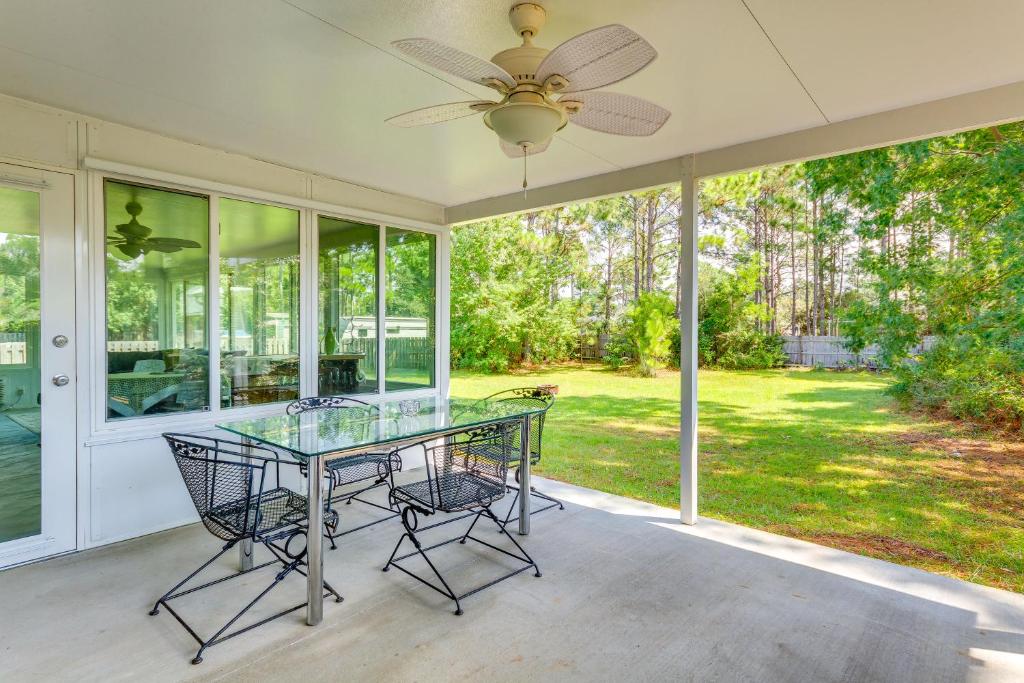 a screened porch with a glass table and chairs at 4 Mi to Beach Family-Friendly Home in Navarre in Navarre