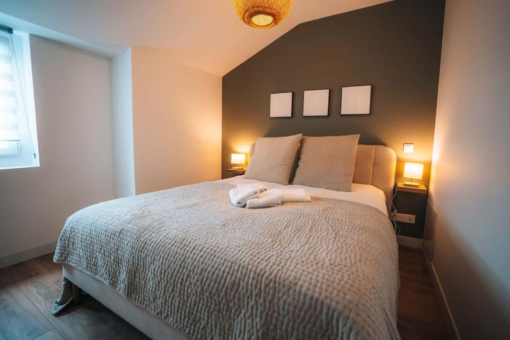 a white dog laying on a bed in a bedroom at Le Berry Sweet - La Douceur de vivre - Proche Gare in Châteauroux