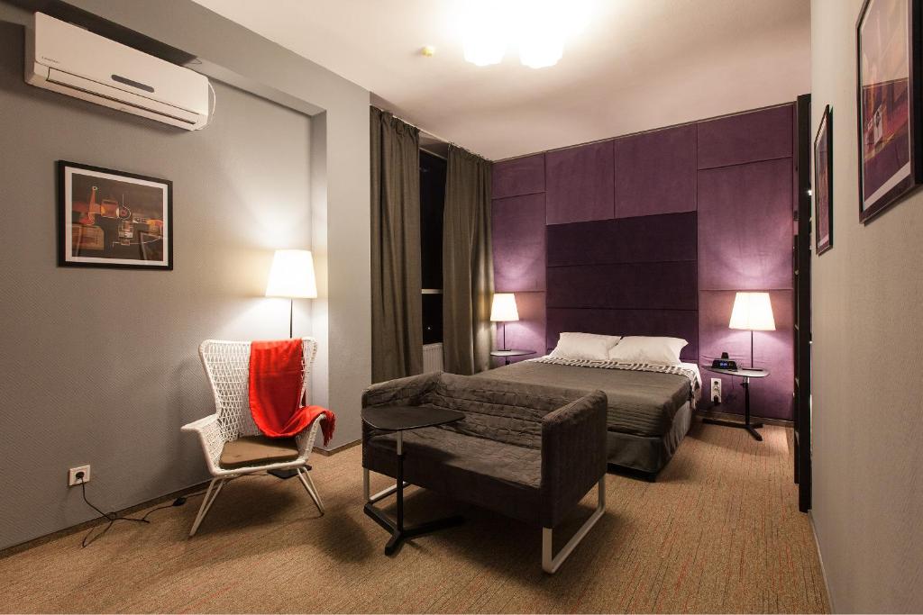 ドニプロにあるNewportのベッドと椅子付きのホテルルーム