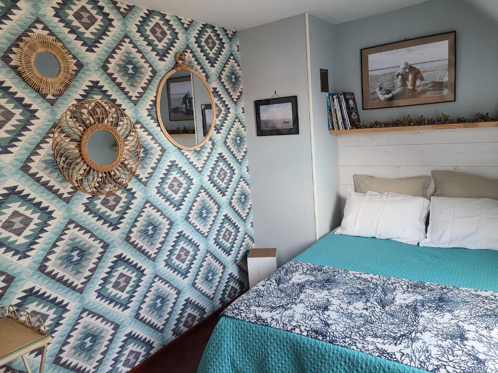 - une chambre avec un lit et un mur avec des miroirs dans l'établissement Villa " Rosina ", à Fort-Mahon-Plage
