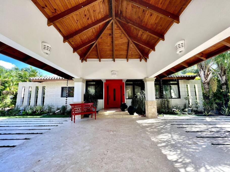 a large building with a red bench in front of it at Villa Cajuiles 13, Casa de Campo in La Romana