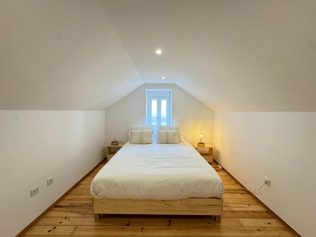 une chambre avec un grand lit blanc avec une fenêtre dans l'établissement Estoril Escape - Family & Friends Beach Getaway, à Estoril