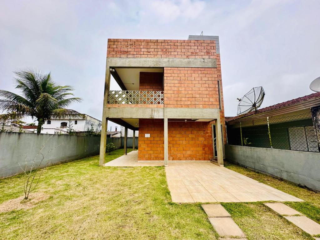 a brick building with a balcony on top of it at Casa com Vista do Mar e Montanha in Peruíbe