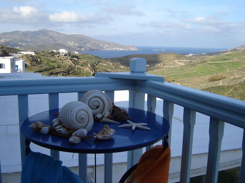 una mesa azul con conchas en el balcón en Blue & White Studios, en Ano Mera