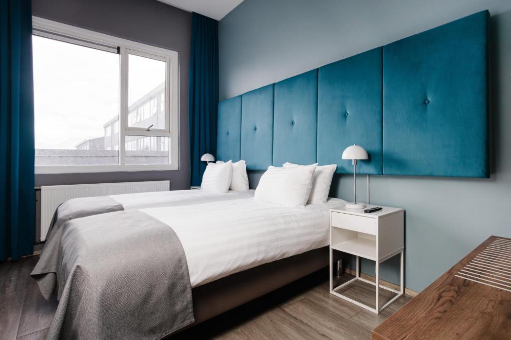 Postel nebo postele na pokoji v ubytování ODDSSON Midtown Hotel