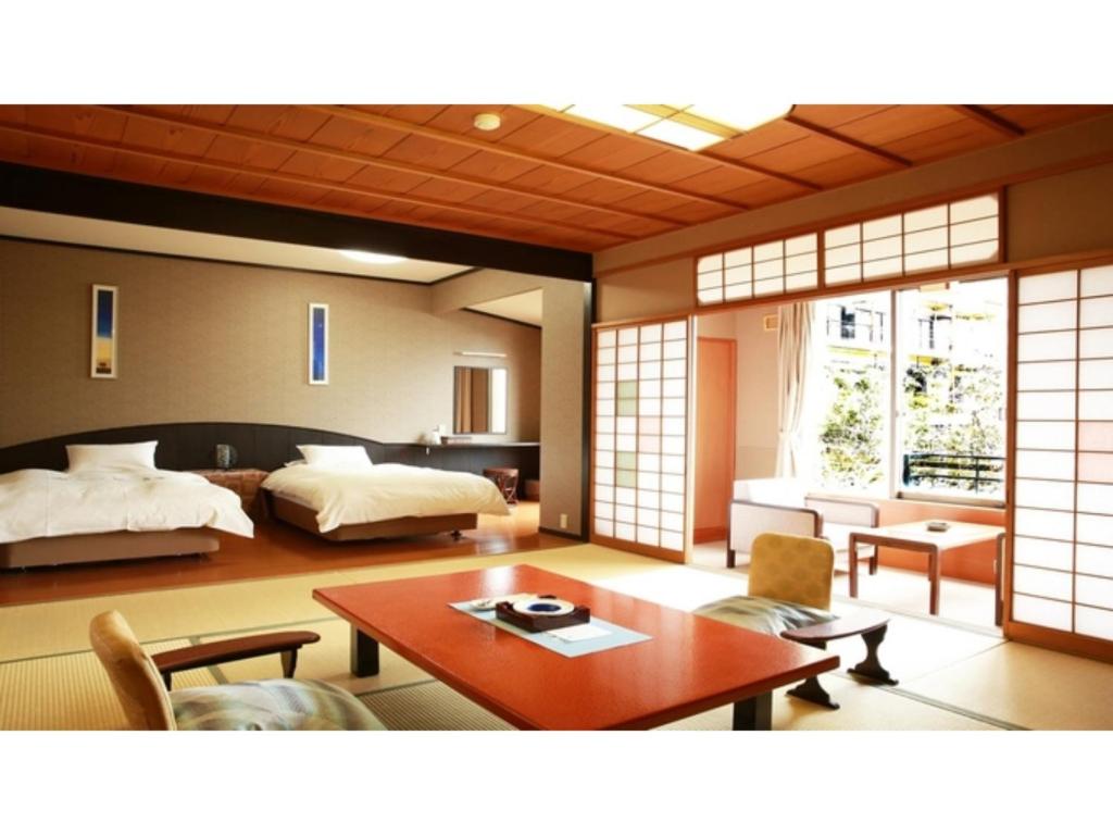 a room with a bedroom with a bed and a table at Tokigasane - Vacation STAY 15860v in Kaga