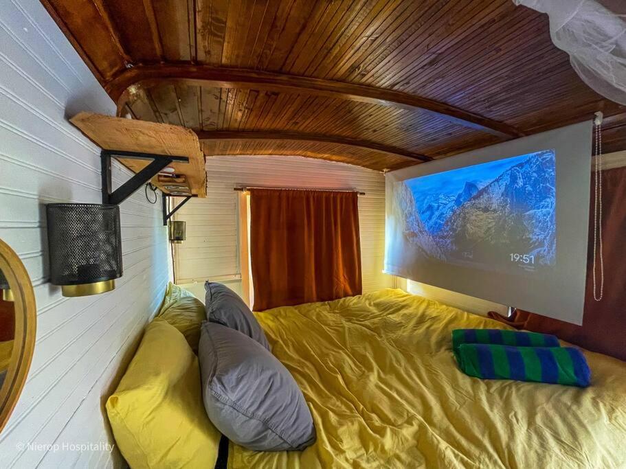 a room with a couch and a flat screen tv at Winterharde pipowagen met hottub, bbq & uitzicht in Luttelgeest