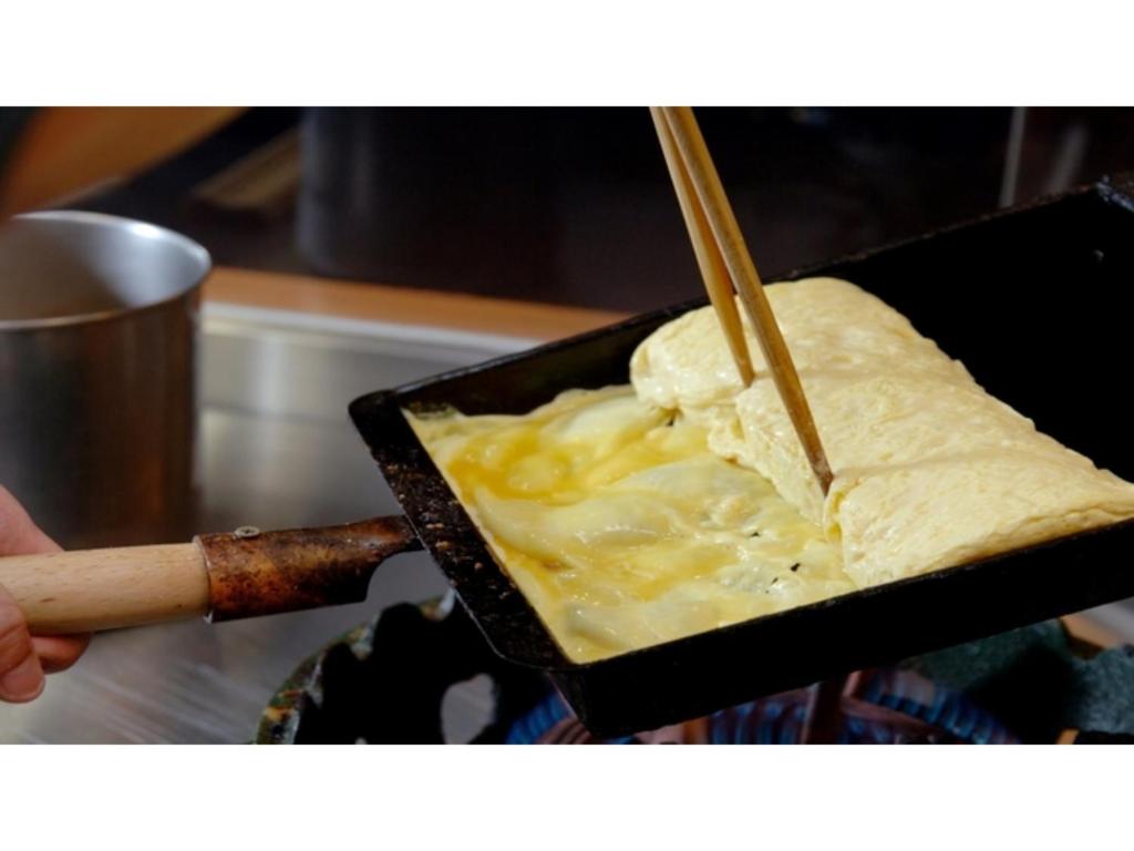 a person holding a container of food with chop sticks at Tokigasane - Vacation STAY 15859v in Kaga