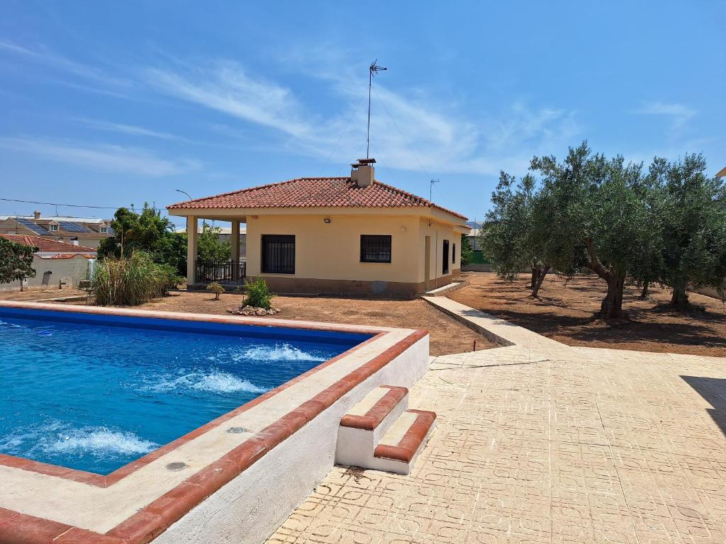 a villa with a swimming pool in front of a house at Villa cerca de Valencia con piscina junto a la montaña in Vilamarxant
