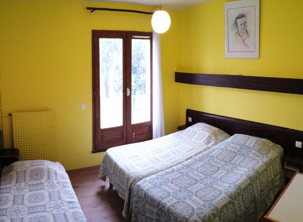 Rúm í herbergi á Friendly Auberge